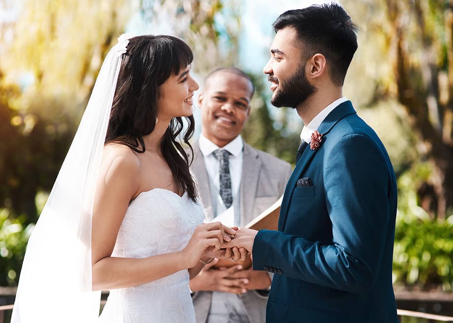 Happy couple exchanging vows during their wedding ceremony. — PeopleImages.com - Yuri A // Shutterstock