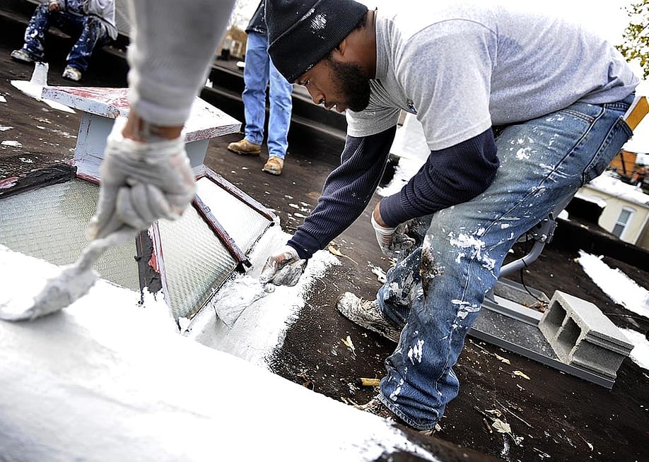 Karim Peoples help to make preparations to make it a cool roof in Baltimore. — Mark Gail // The Washington Post via Getty Images