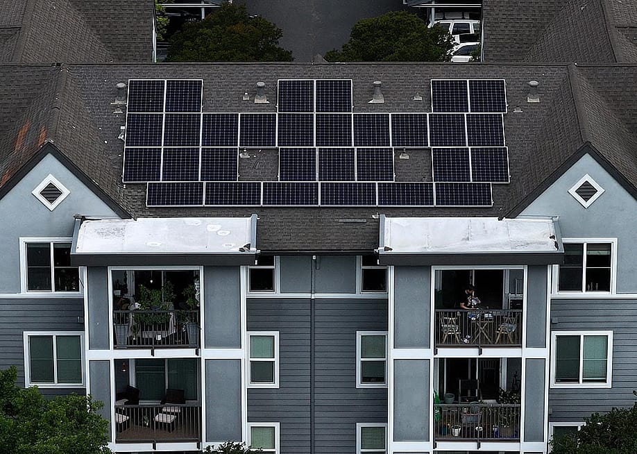 Aerial view of solar panels are on the roof of an apartment complex in California. — Justin Sullivan // Getty Images