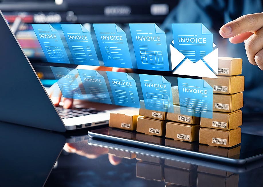 Concept of technology in accounting illustrated by 10 blue virtual invoice icons superimposed over person using a laptop computer. — HAKINMHAN // Shutterstock