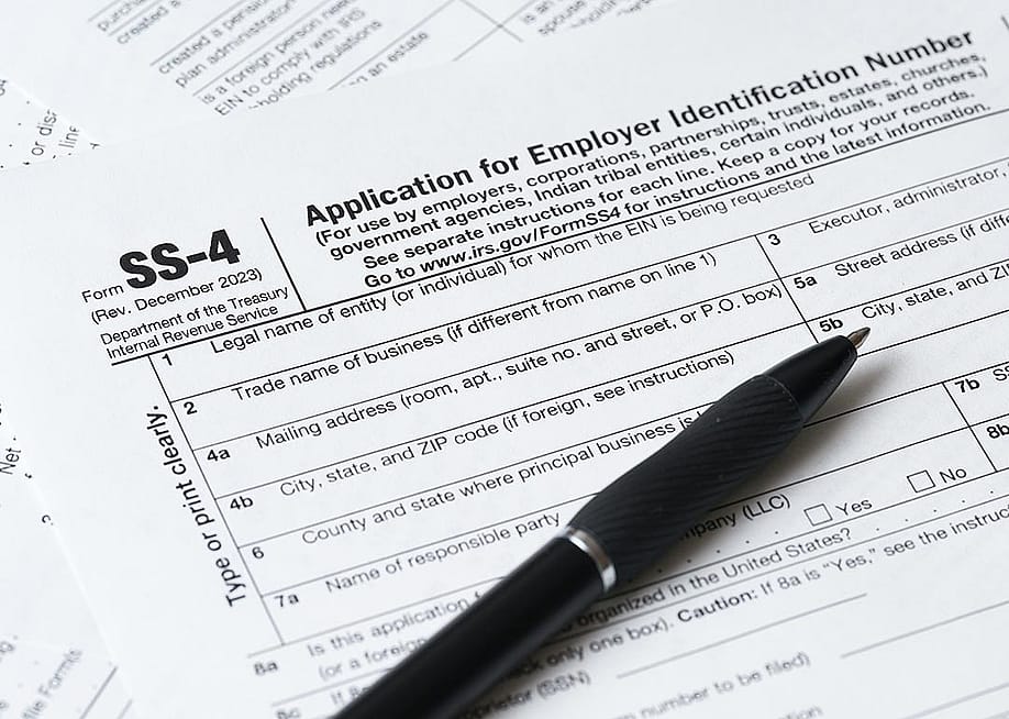 Pen resting on paper application for EIN, the SS-4 form. — MMPhoto21 // Shutterstock