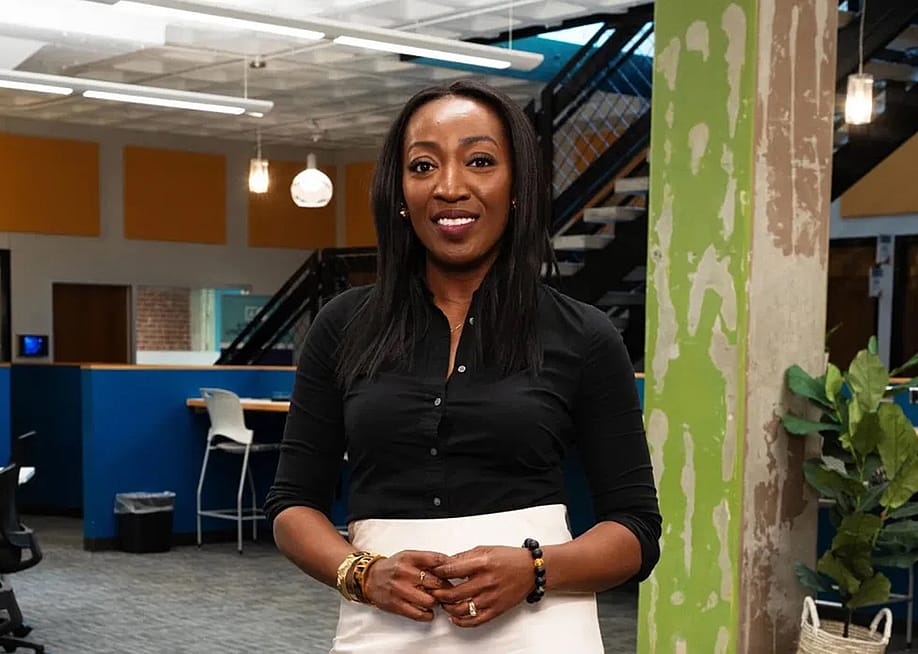 Daisy Magnus-Aryitey poses for a portrait wearing a black button-up shirt and high-waisted white skirt. — Endia Beal for EHRP and Fast Company