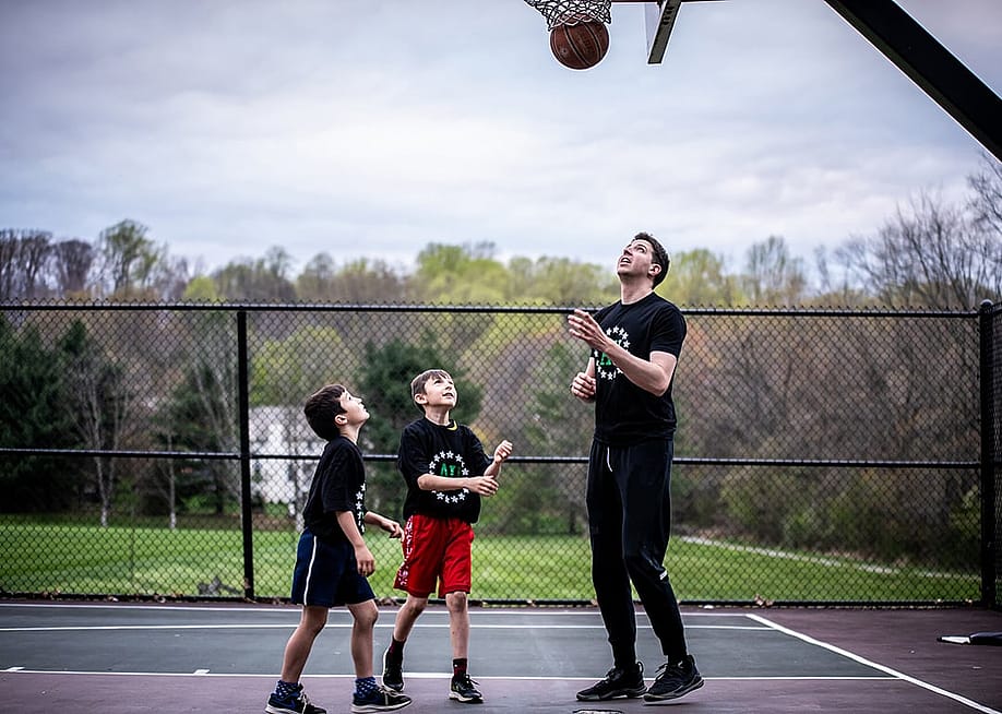 A private sports coach in a basketball session with two young boys. — Athletes Untapped