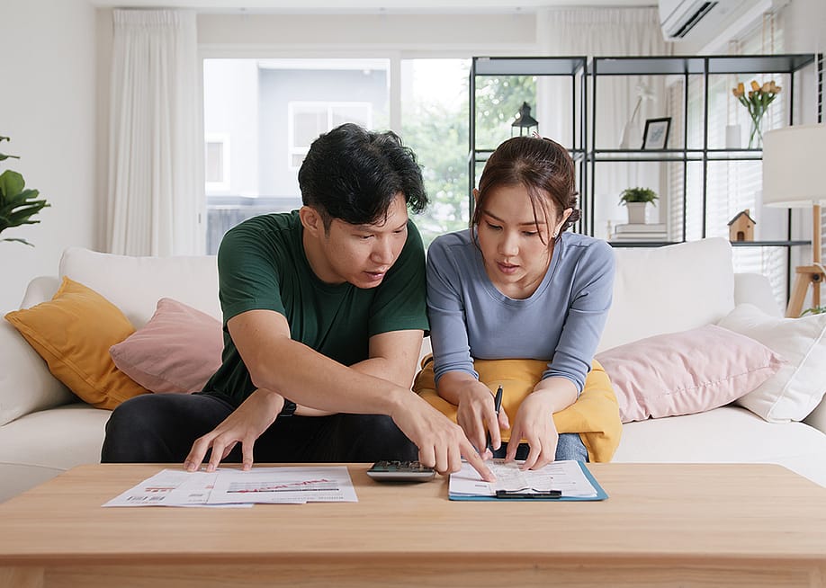A young couple organizing expenses. — Chay_Tee // Shutterstock
