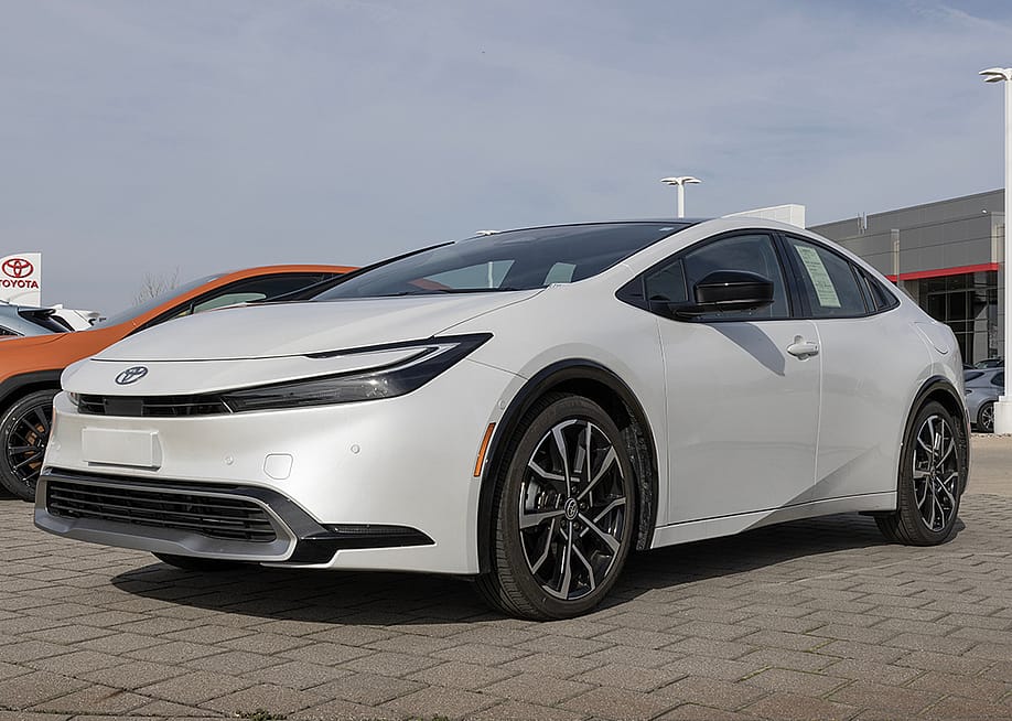 A used white Toyota Prius on display at a dealership. — Jonathan Weiss // Shutterstock