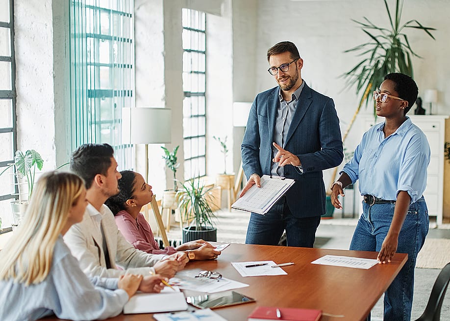 Five members of a diverse business team in a meeting in an office. — pics five // Shutterstock