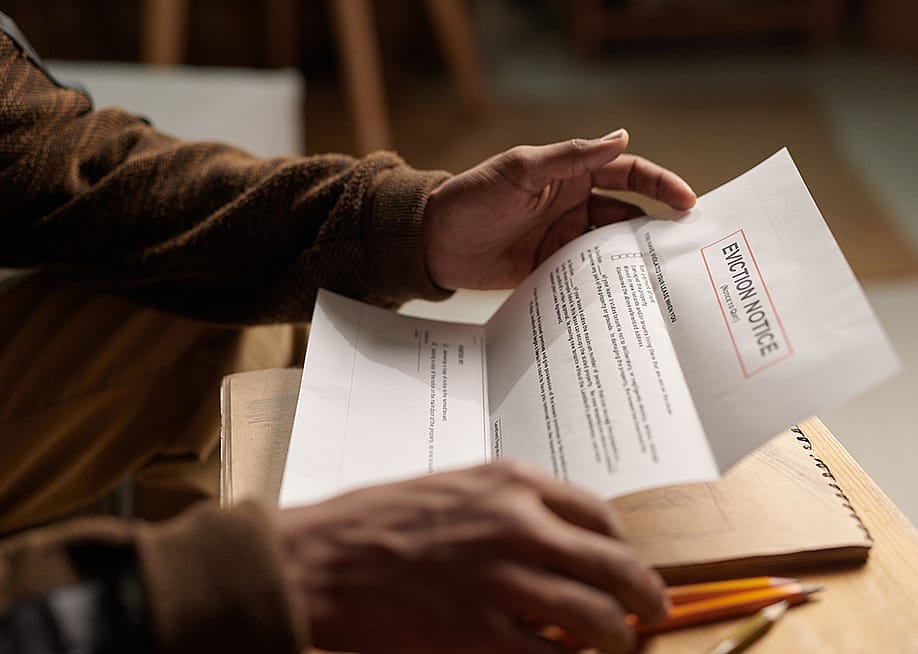 Close-up of a person reading an eviction notice letter. — Pressmaster // Shutterstock