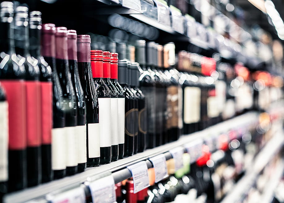 Bottles of wine on a shelf in a liquor store. — Tero Vesalainen // Shutterstock