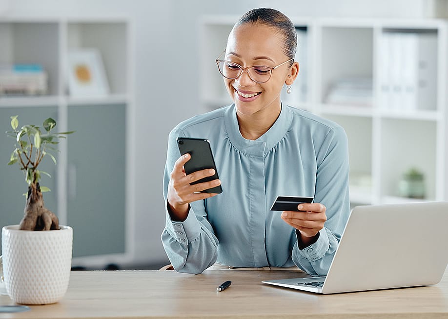 A female business professional using a credit card for an online purchase while working. — PeopleImages.com - Yuri A // Shutterstock