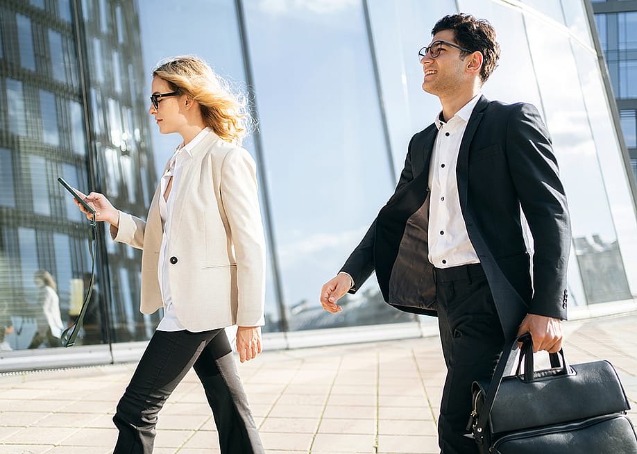 Two business professionals on the way to their work. — muse studio // Shutterstock