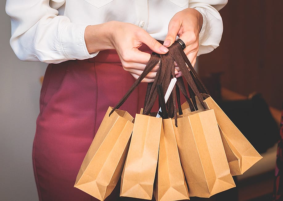 Employee holding corporate gift bag packages. — Tsuguliev // Shutterstock