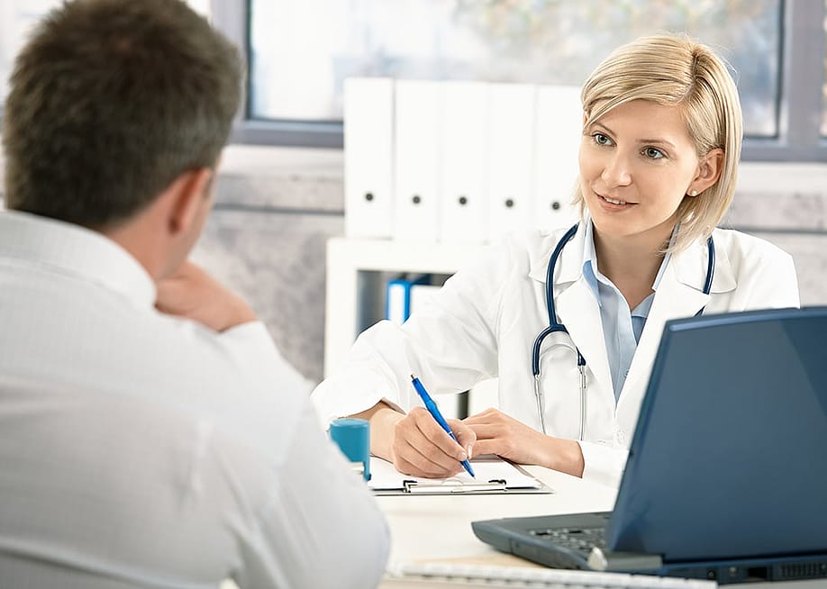 A doctor takes notes while consulting with her patient. — StockLite // Shutterstock