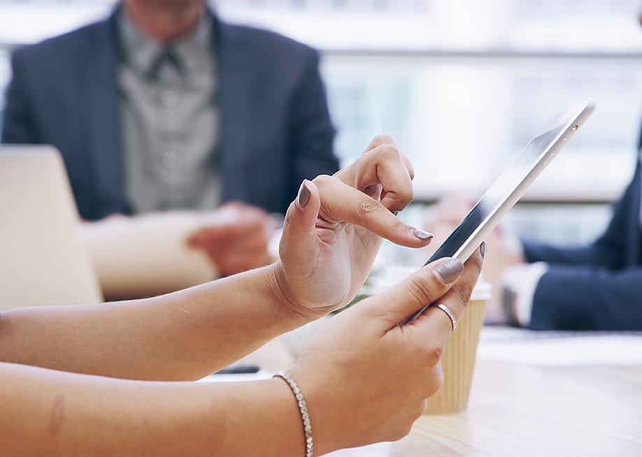 Businesswoman using a tablet during a team meeting. — PeopleImages.com - Yuri A // Shutterstock
