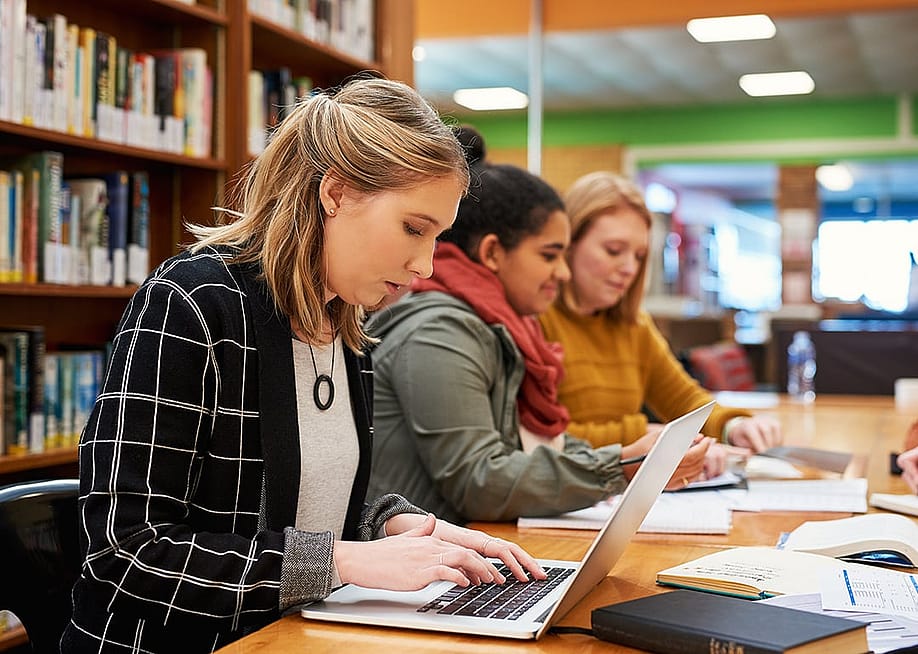 A female marketing professional composes email in her laptop in an office library. — PeopleImages.com - Yuri A // Shutterstock