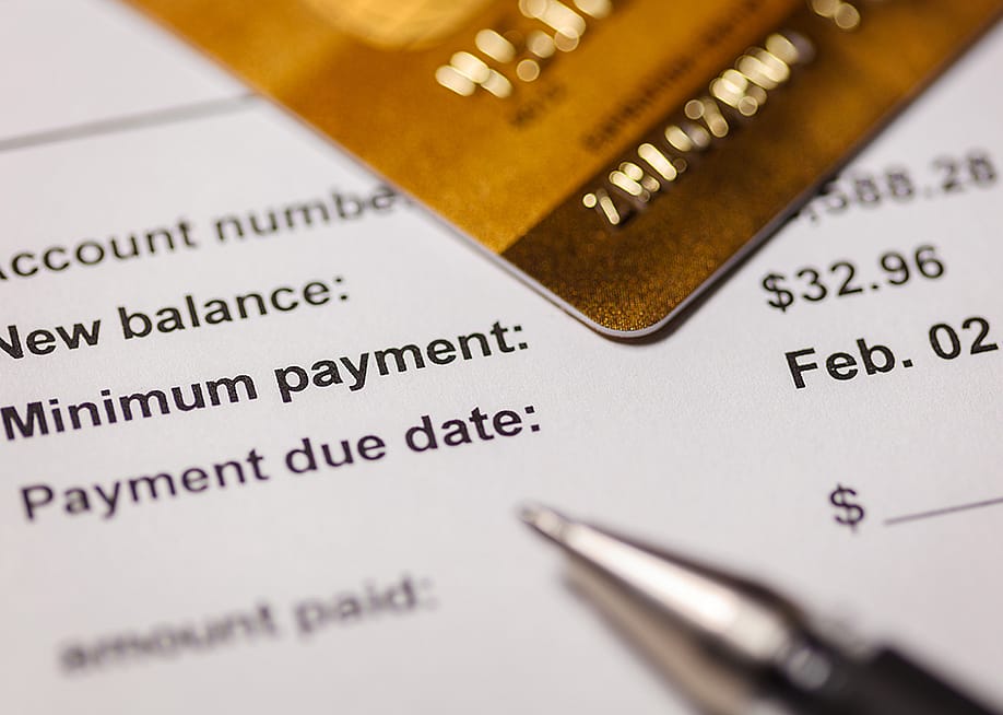 Credit card on top of a bill statement closed up on the minimum amount and due date. — Feng Yu // Shutterstock
