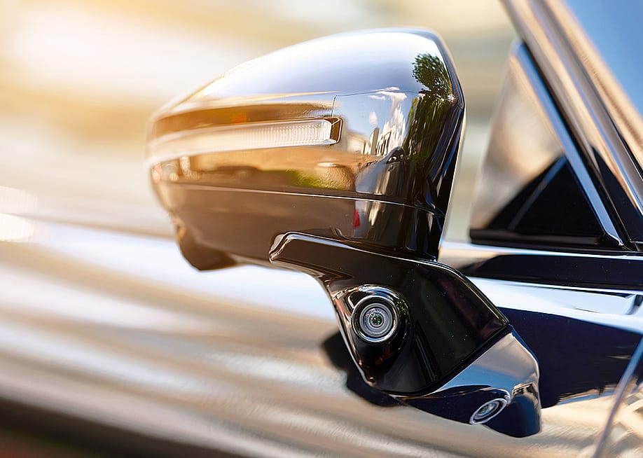 Side area of a car showing the rear mirror for blind spot monitoring. — Tricky_Shark // Shutterstock