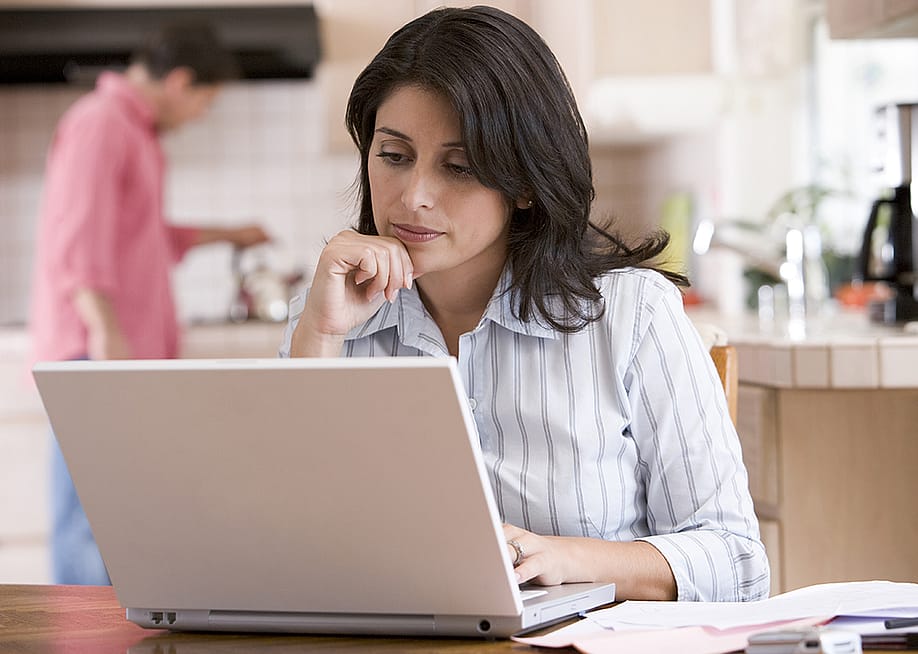 Woman using a laptop at her home's kitchen. — Monkey Business Images // Shutterstock