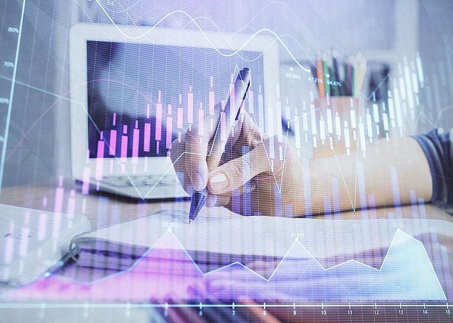 Businesswoman writing notes illustrated with finance, forex charts graphics. — Peshkova // Shutterstock