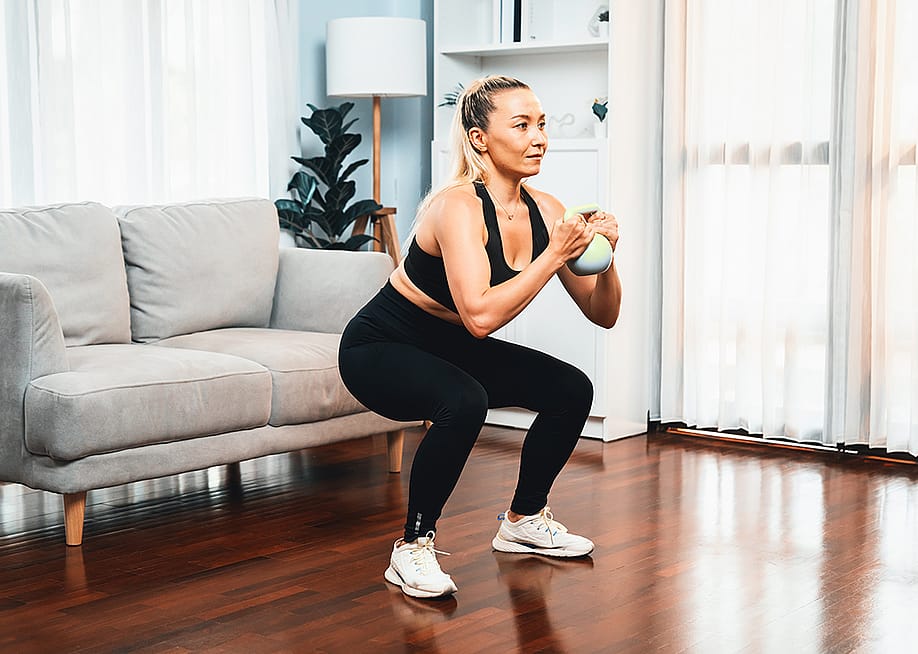 Woman at home in a leg day training session. — Summit Art Creations // Shutterstock