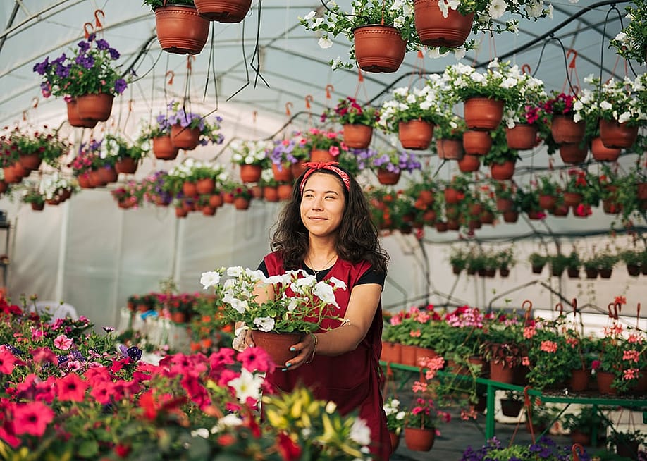A small business owner in her flowers and plants site. — Daniel Besic // Shutterstock