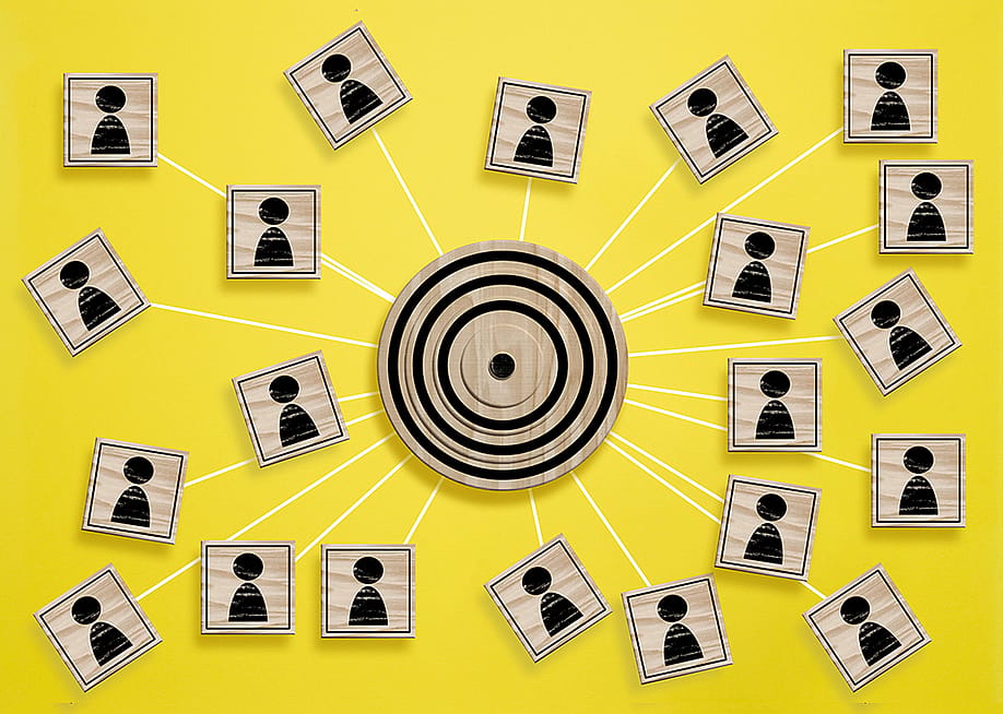 A wooden target board connecting many wooden cube with a figure icon. — NDanko // Shutterstock