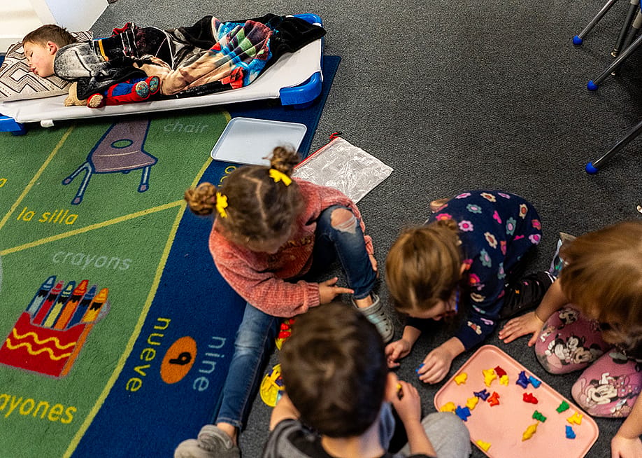 A group of young children during nap time at TLC for Tots daycare center in Nampa, Idaho. One child is sleeping while others are playing. — Melina Mara // The Washington Post via Getty Images