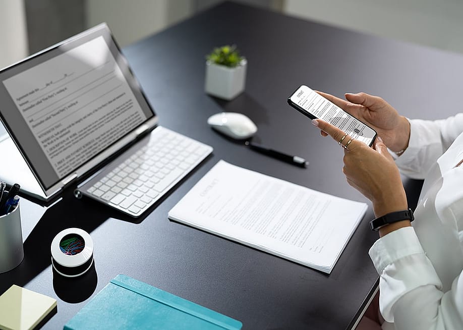 Employee at work manually scanning a document with a phone. — Andrey_Popov // Shutterstock