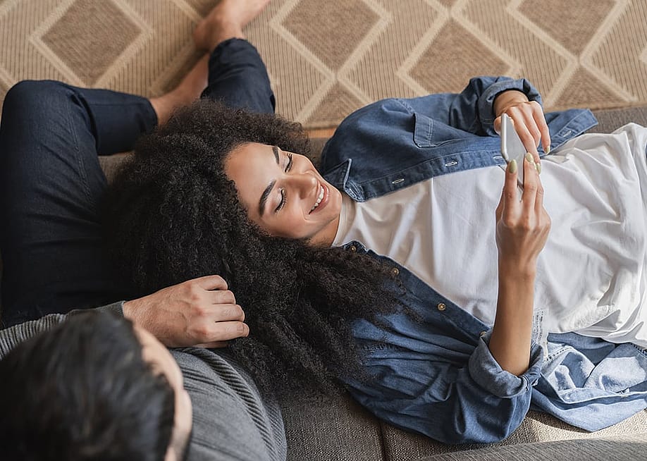 Young couple at home browsing information using a phone. — Inside Creative House // Shutterstock