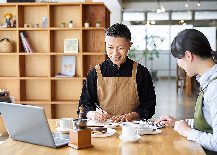A cafe small business owner calculating costs of products. — mapo_japan // Shutterstock