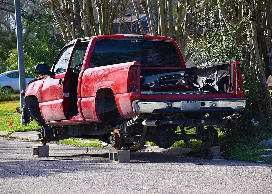 A stolen red pick-up truck in Texas, stripped and hoisted with bricks. — Artistic Operations // Shutterstock