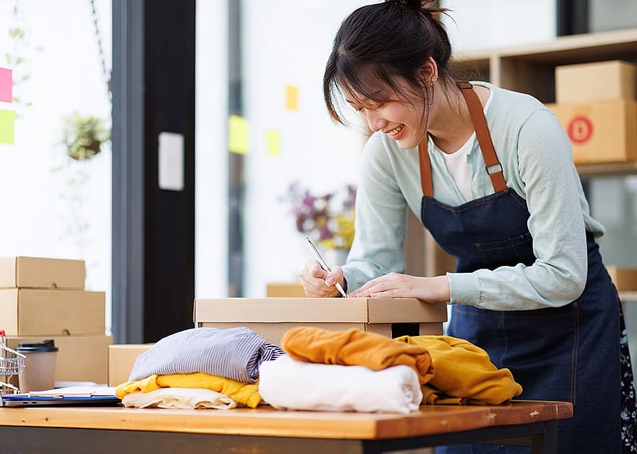 A young female small business owner preparing an order for packaging. — David Gyung // Shutterstock
