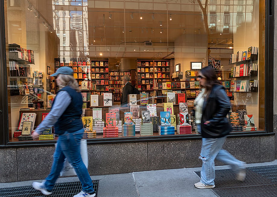 People passing by the glass display of a book store in Manhattan, New York. — Spencer Platt // Getty Images