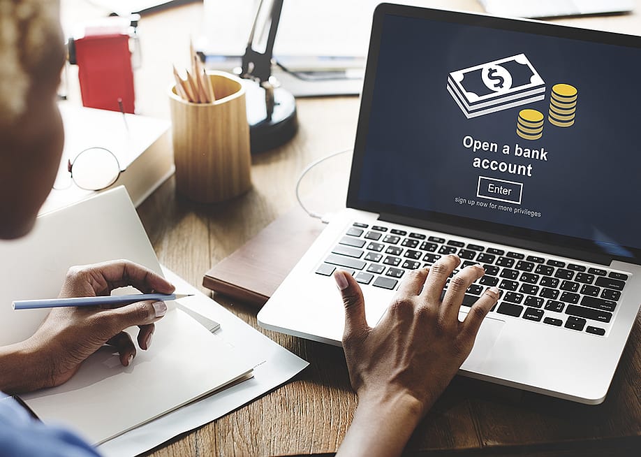 A businesswoman navigates a page to open a bank account. — Rawpixel.com // Shutterstock