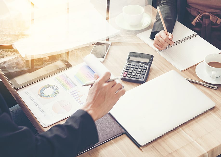 Business partners review financial documents. — photofriday // Shutterstock