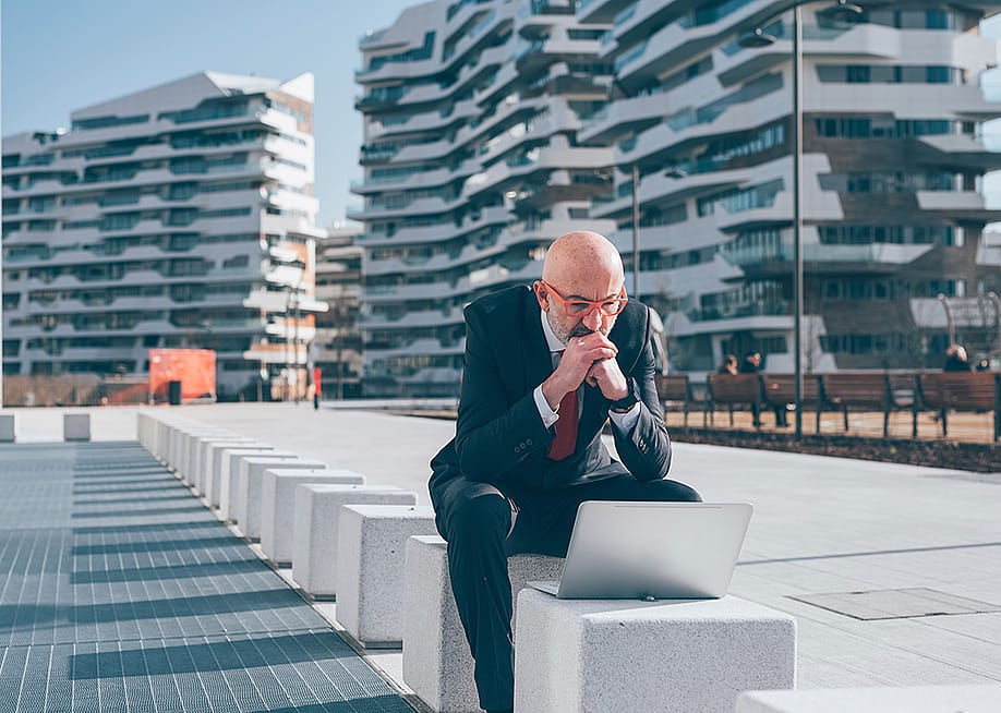 Businessman sitting outdoors and concentrates on his laptop. — Eugenio Marongiu // Shutterstock