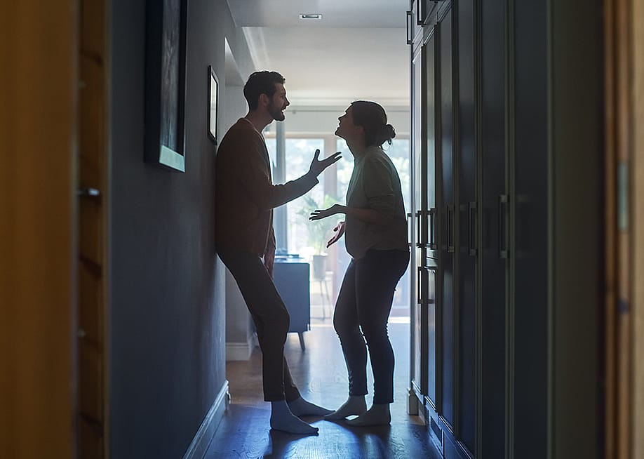 A couple fighting in a hallway of their apartment. — Gorodenkoff // Shutterstock