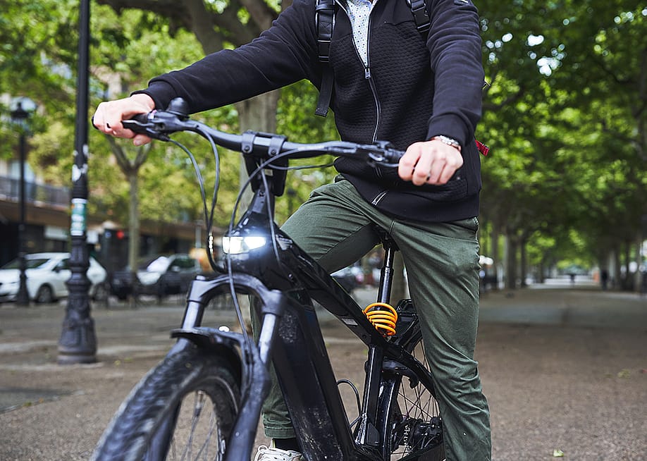 Man riding electric bicycle on a street. — Marc Elias // Shutterstock