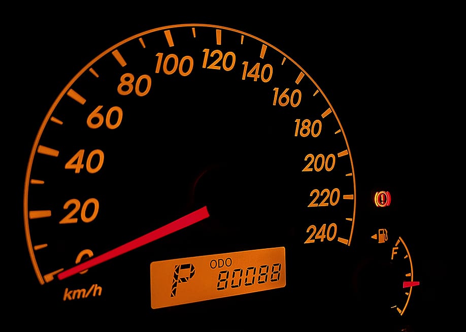 A car's orange-colored speed odometer displaying 80,088km. — Supakorn Angaumnuaysiri // Shutterstock