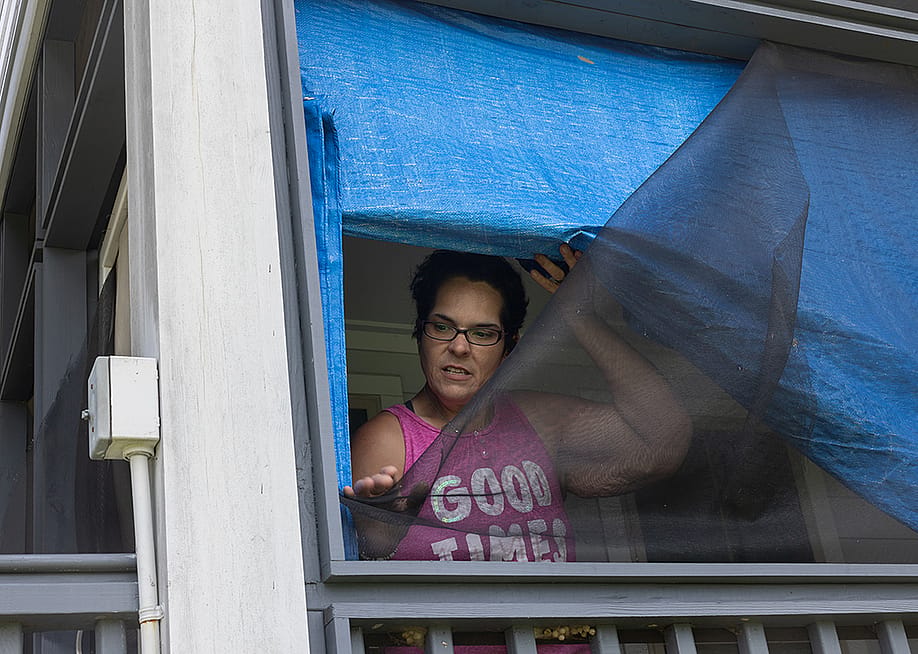 Kristi Naquin shows wind-damaged screens at her 3-year-old home which she says are substandard. They were built as part of the first federally funded relocation project in the United States. — Jeffrey Basinger // Floodlight