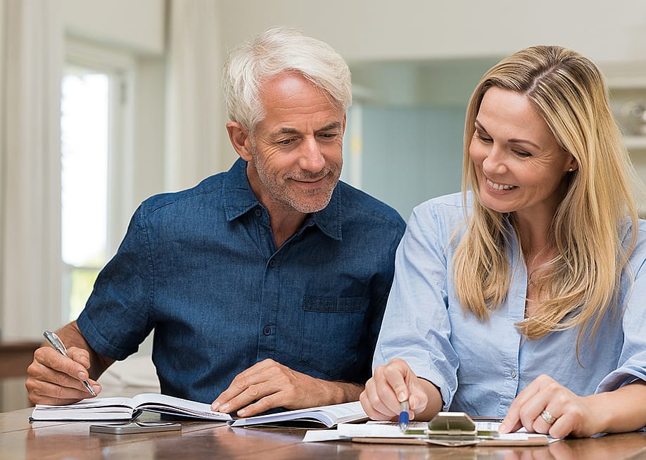 A middle-aged couple reviewing documents at home. — Ground Picture // Shutterstock