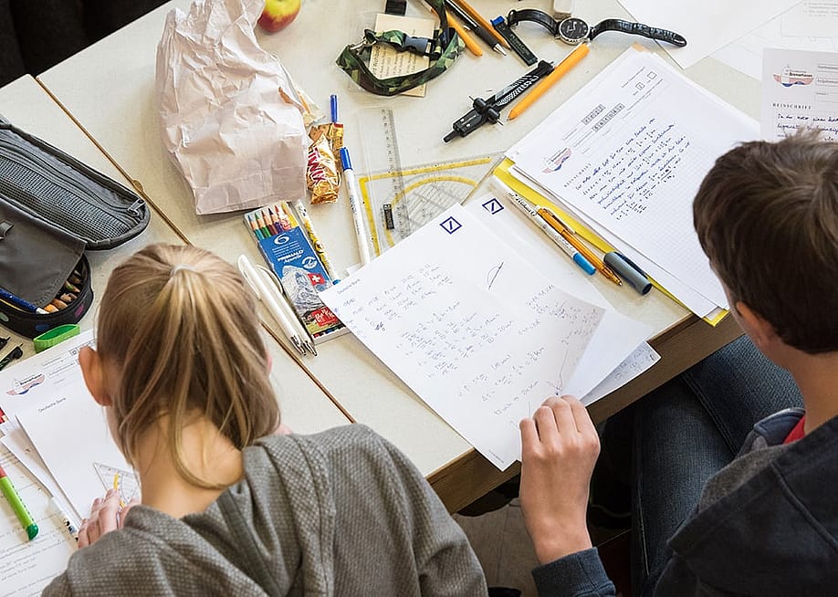 A pair of mathematics students writing on paper during the finals of a math competition. — Ingo Wagner // picture alliance via Getty Images
