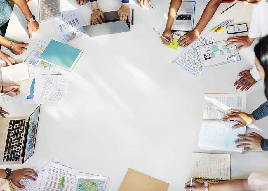 Students with their books, laptops, and papers around a table. — Rawpixel.com // Shutterstock