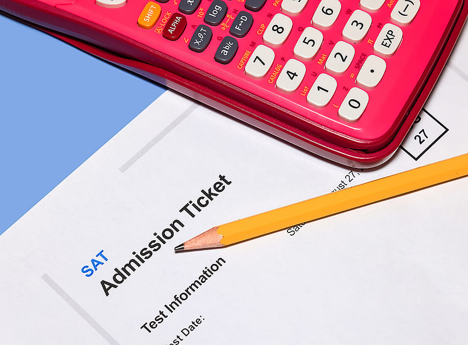 An SAT admission ticket under a pencil and calculator. — SNEHIT PHOTO // Shutterstock