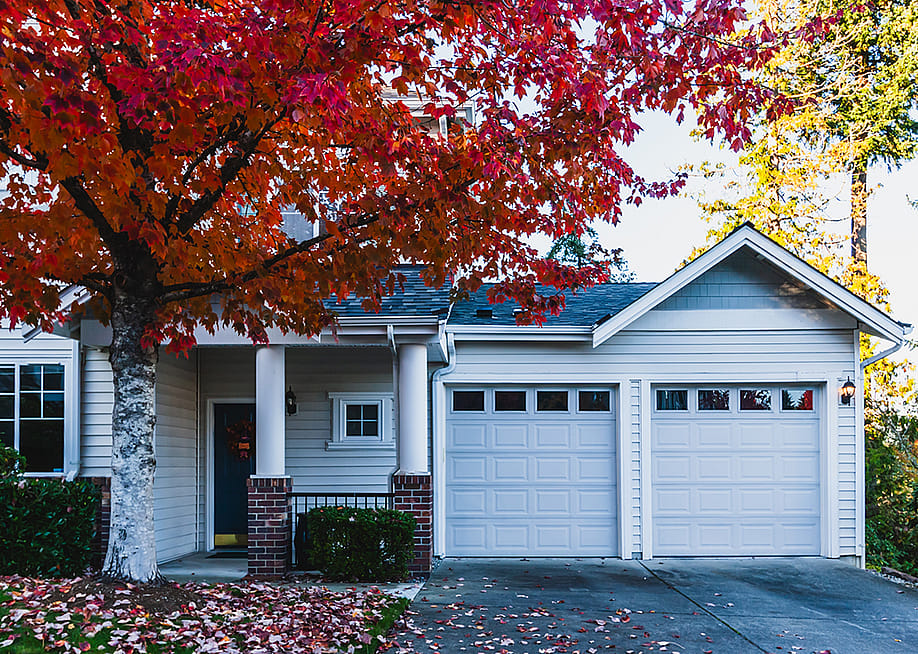 The front of a modern residential home during fall time. — Olya Helms // Shutterstock
