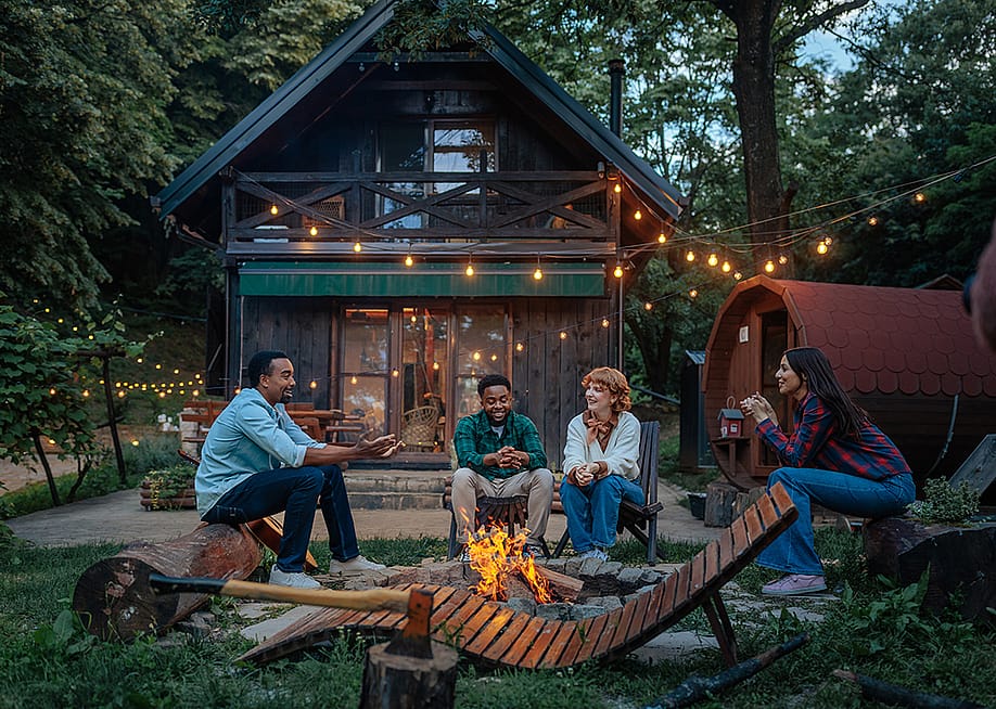 Four people sitting around a fire pit. — bbernard // Shutterstock