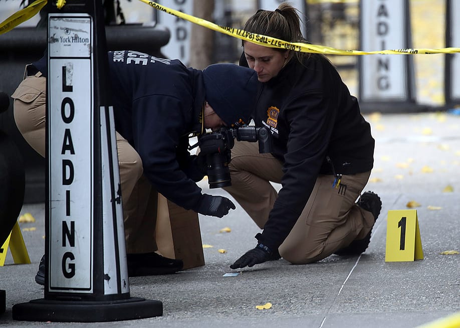 Police take photos as they place bullet casing markers outside of a Hilton Hotel in Midtown Manhattan where United Healthcare CEO Brian Thompson was fatally shot on December 04, 2024 in New York City. — Photo by Spencer Platt // Getty Images