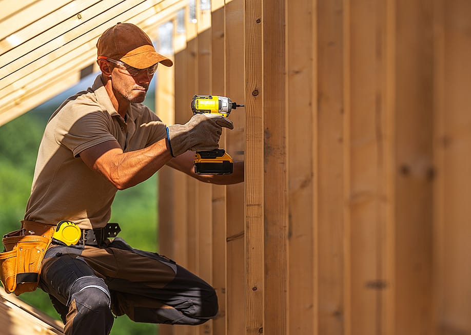 A skilled carpenter securing wooden panels using an electric power drill. — Virrage Images // Shutterstock