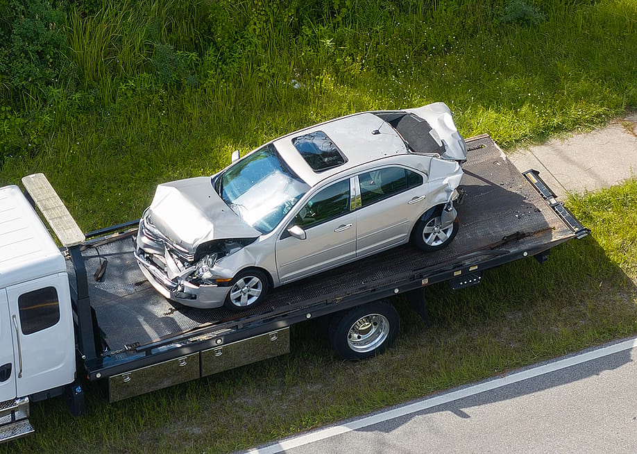 A damaged car loaded on a tow truck from the accident site. — Bilanol // Shutterstock