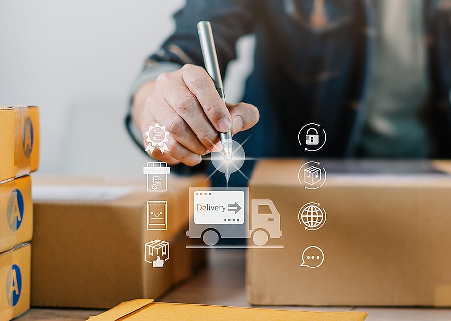 A logistics worker fulfills boxes of orders illustrated with a modern delivery system software graphics. — thanmano // Shutterstock