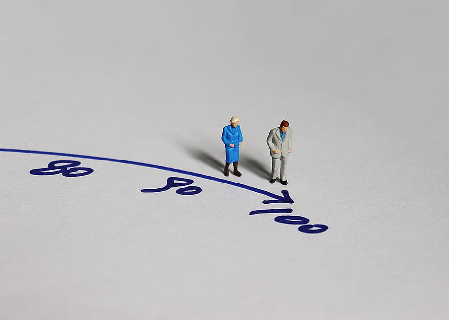 A miniature of an old couple walking towards the figure 100. — Hyejin Kang // Shutterstock